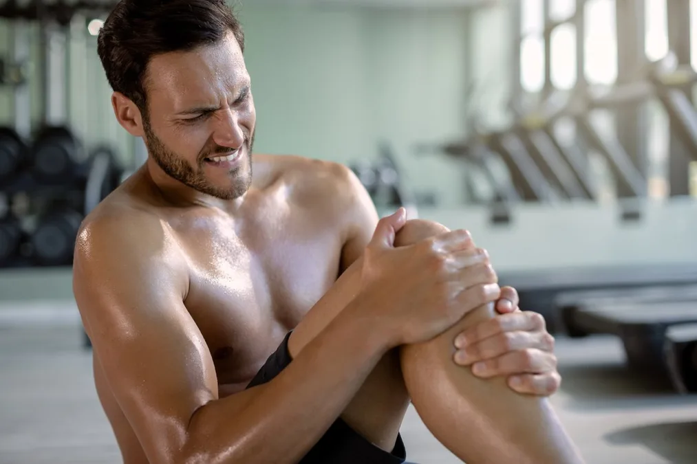 Athlete easing muscle cramps during recovery, supported by IV therapy in Baltimore